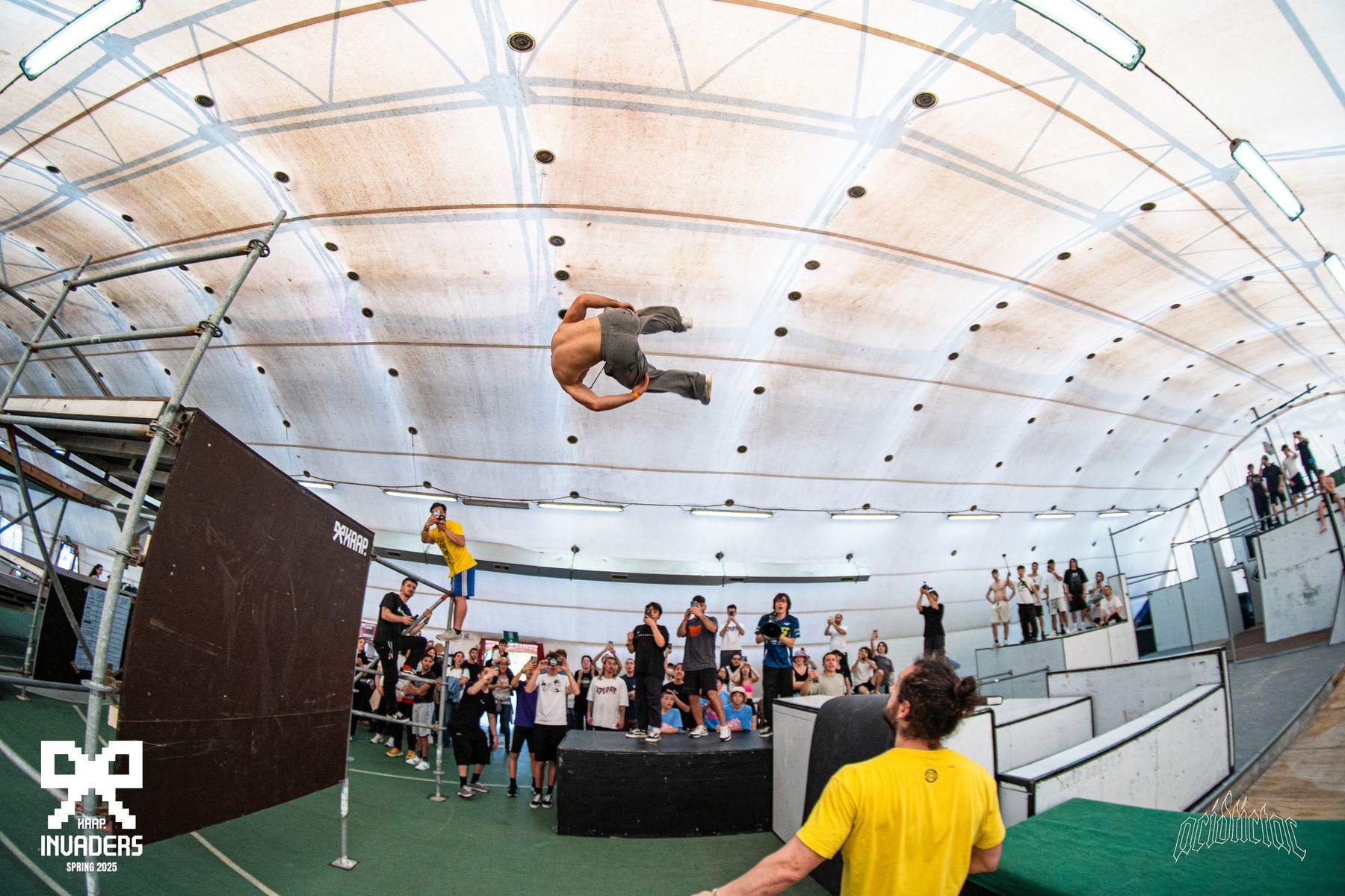 Un atleta a mezz'aria in un salto mortale completo, corpo disteso
