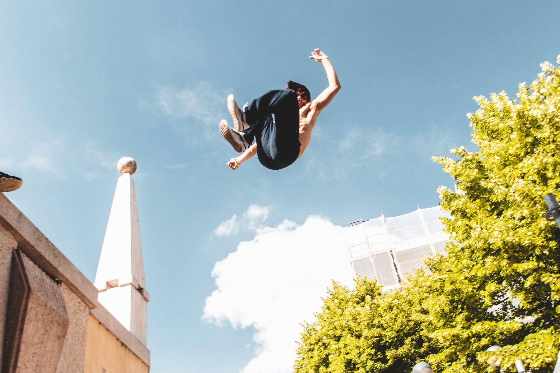 Un atleta esegue un salto all'indietro contro il cielo azzurro