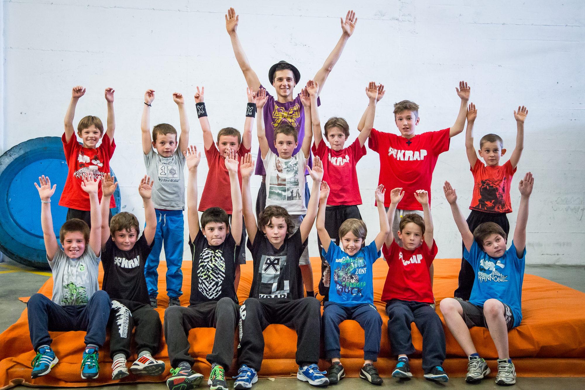 Un gruppo di bambini esulta sul materasso arancione