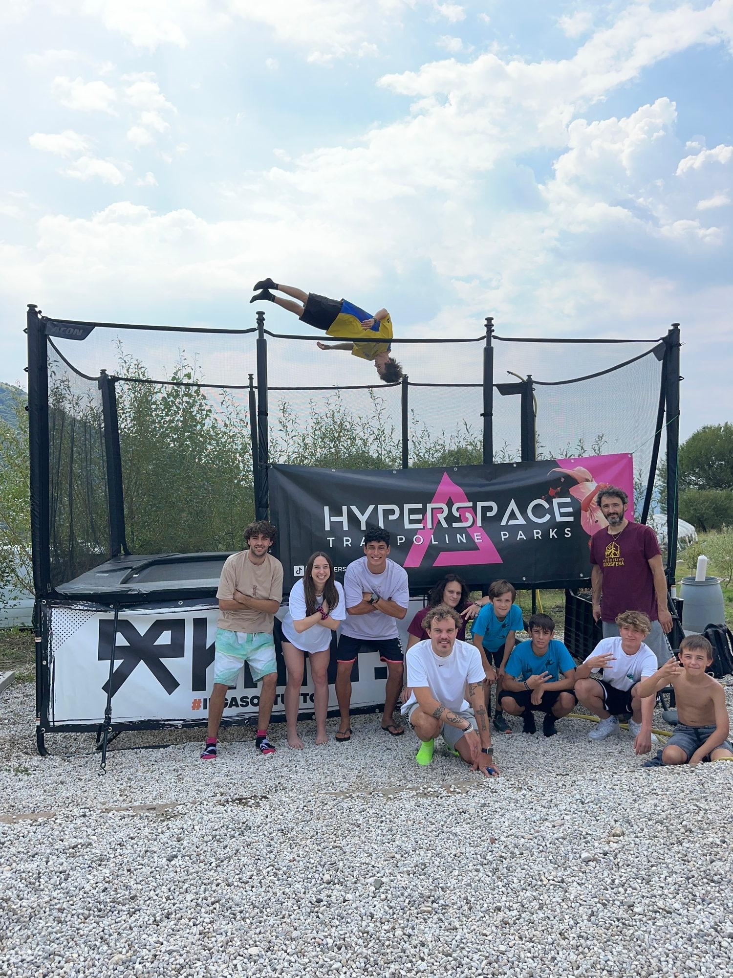 Un salto mortale sul trampolino, con il gruppo che guarda