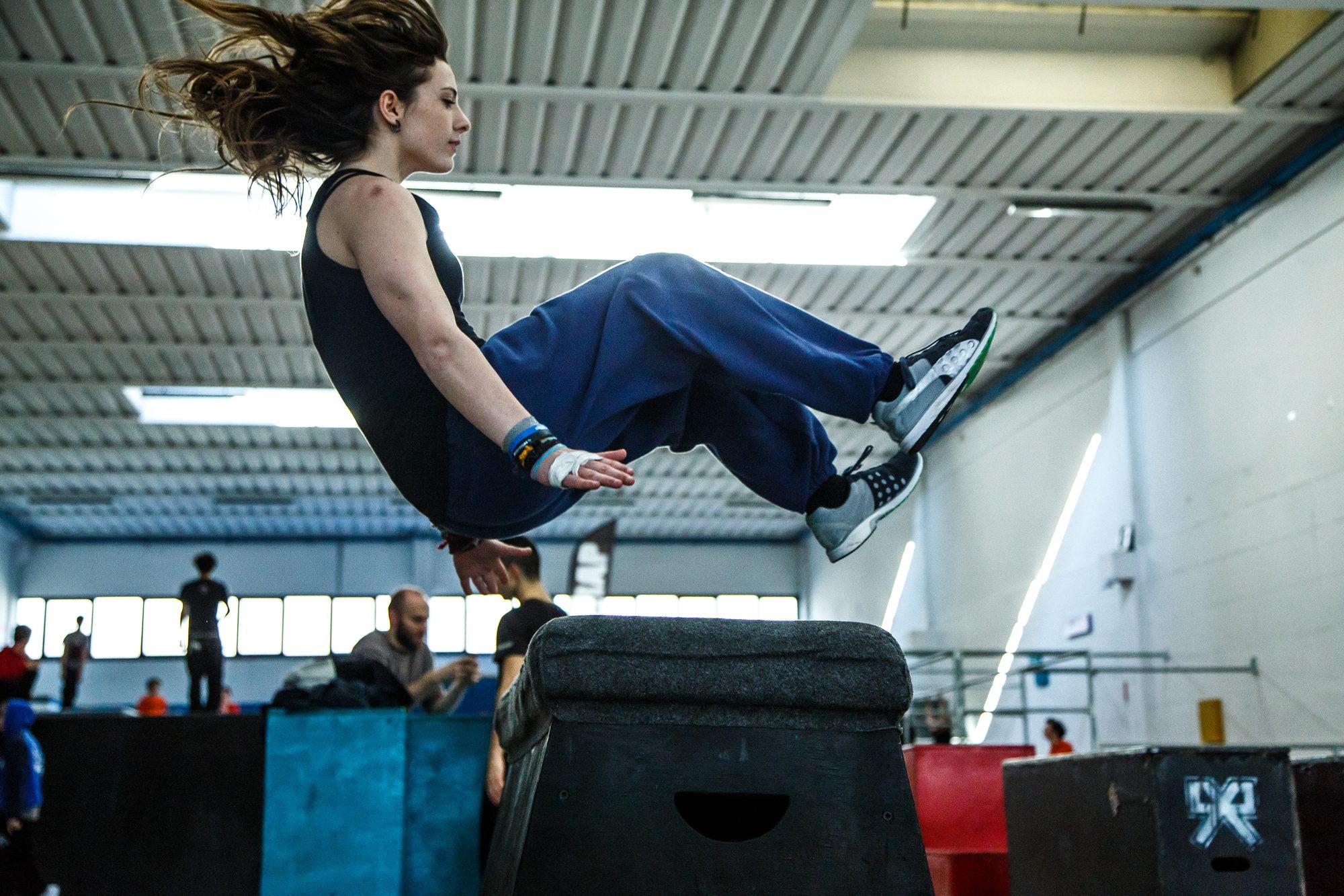 Una ragazza esegue un salto acrobatico, i capelli in aria