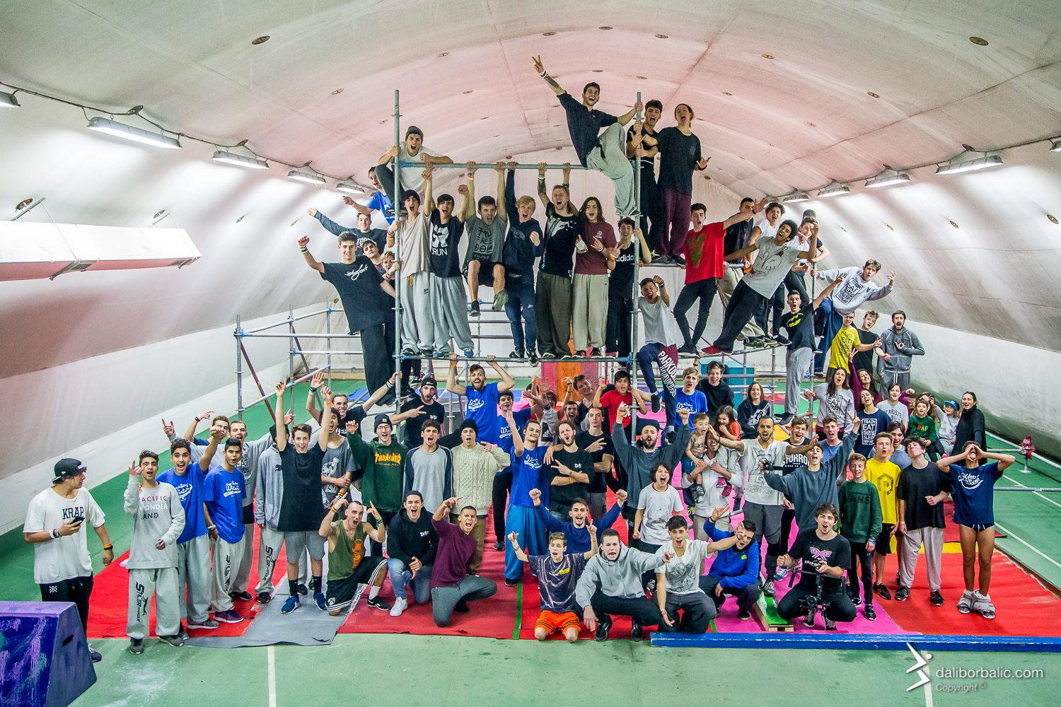 Un gruppo numeroso festeggia insieme sulle gradinate della palestra