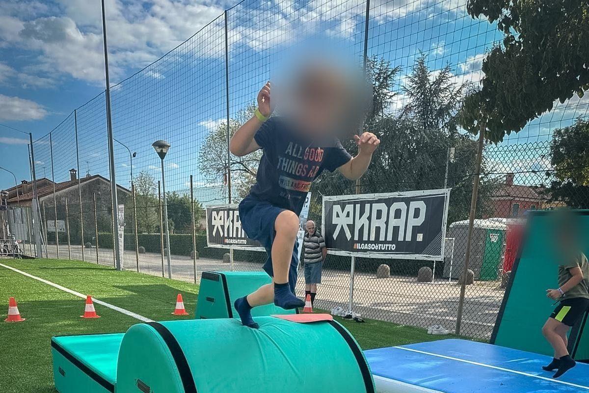 Un bambino salta sopra un blocco imbottito, con gli striscioni KRAP sullo sfondo