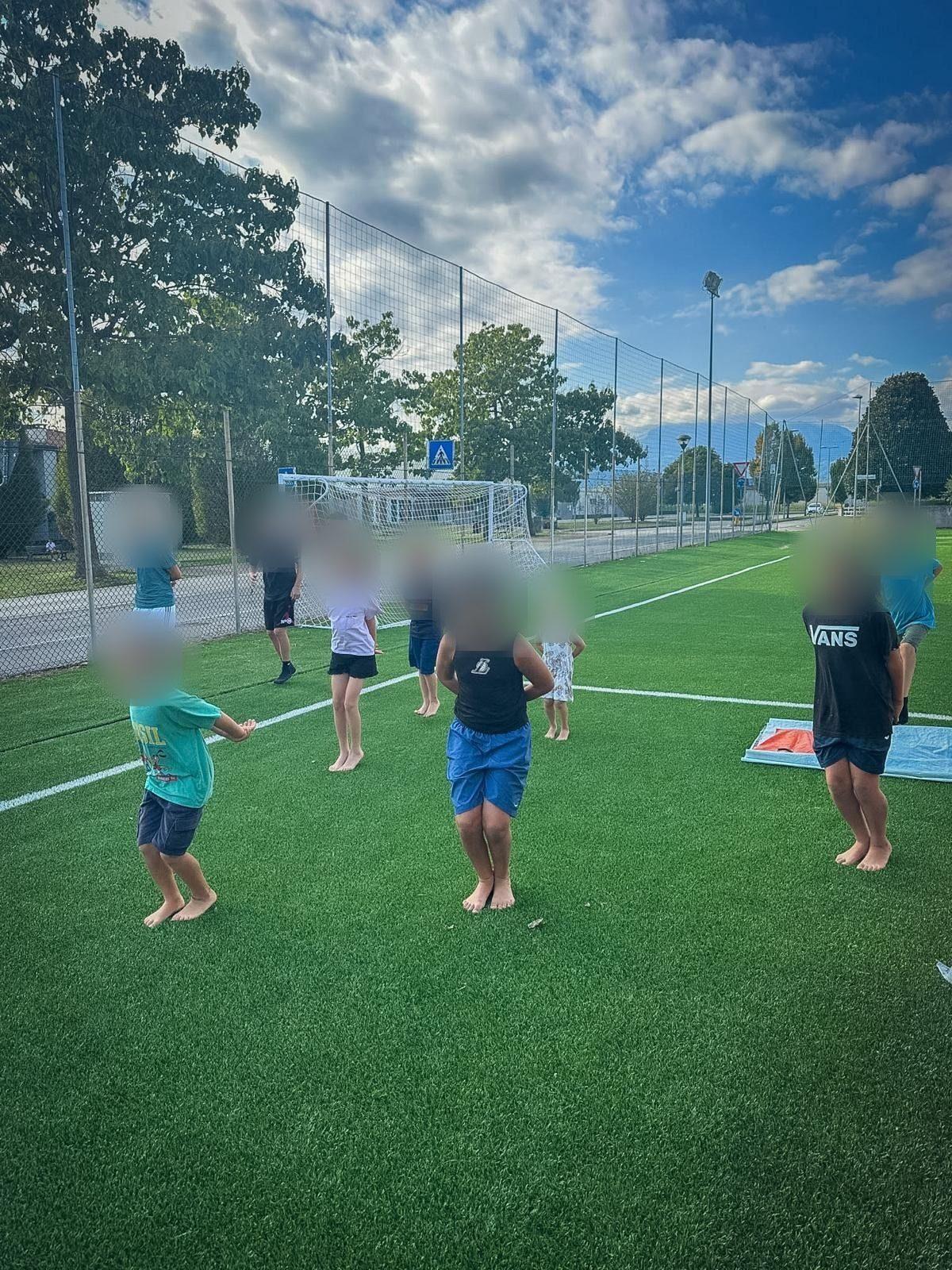 Un gruppo di bambini in piedi sull'erba sintetica