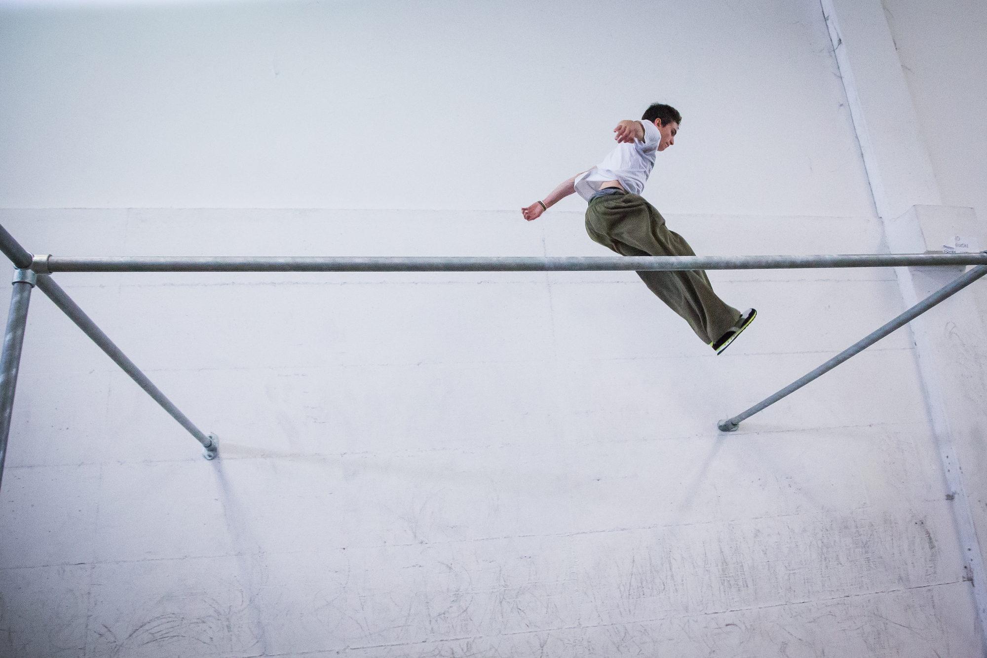Un salto di precisione fra due barre, durante un workshop in palestra